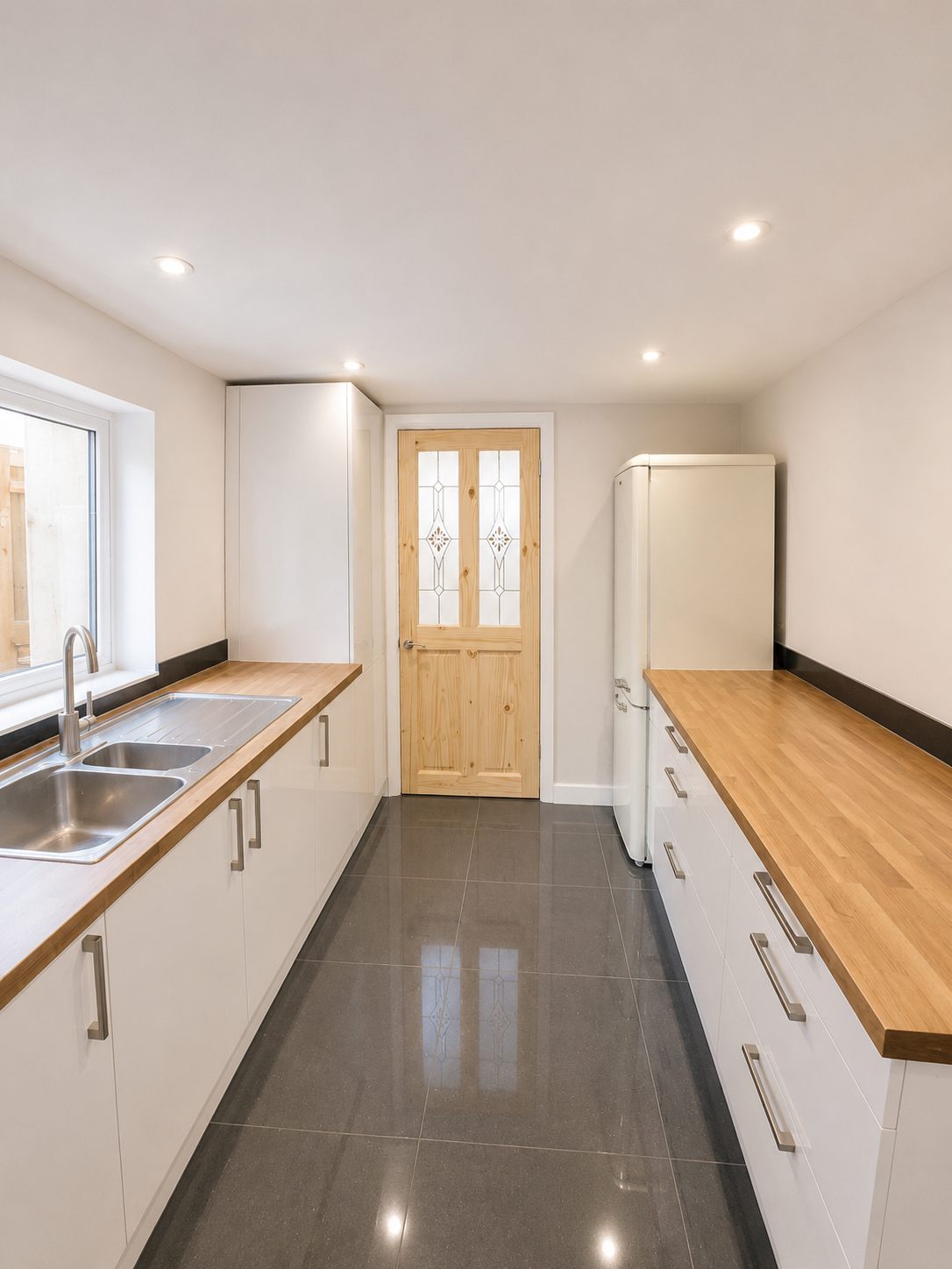 Completed kitchen viewed towards a glazed timber door